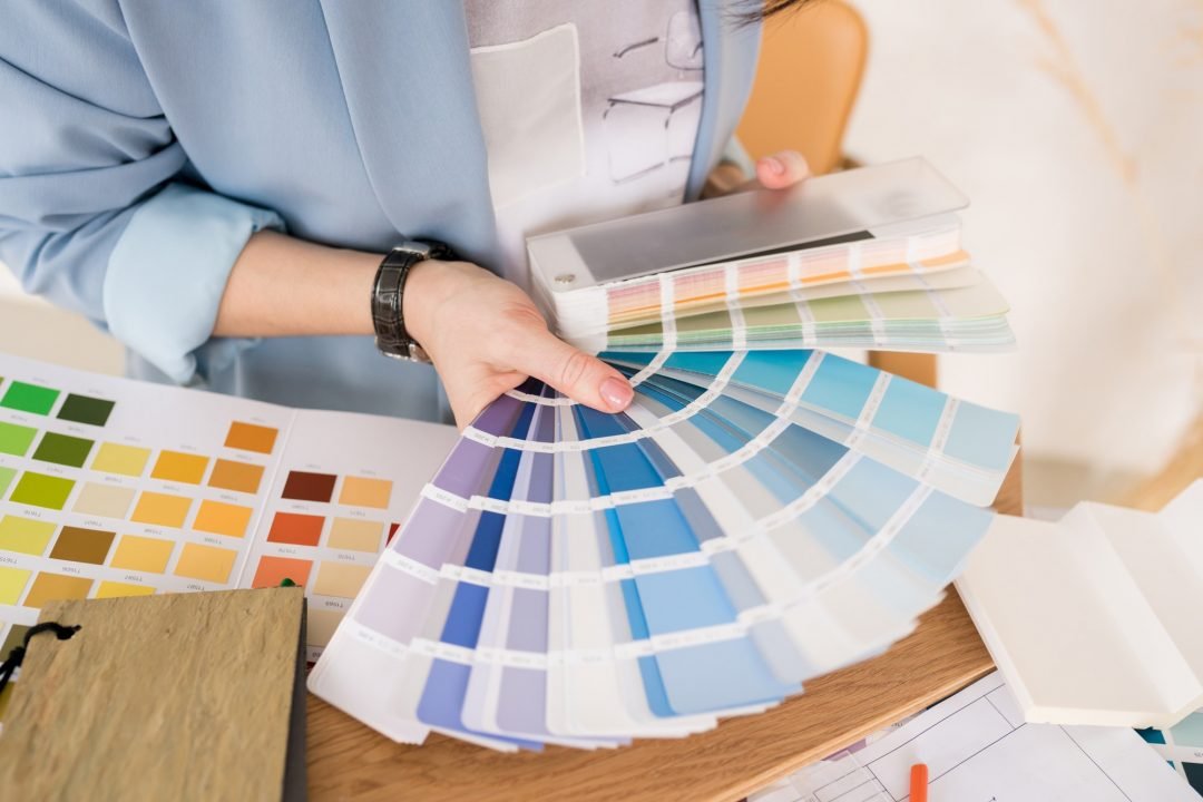 Close-up of architect woman choosing samples of wall paint.